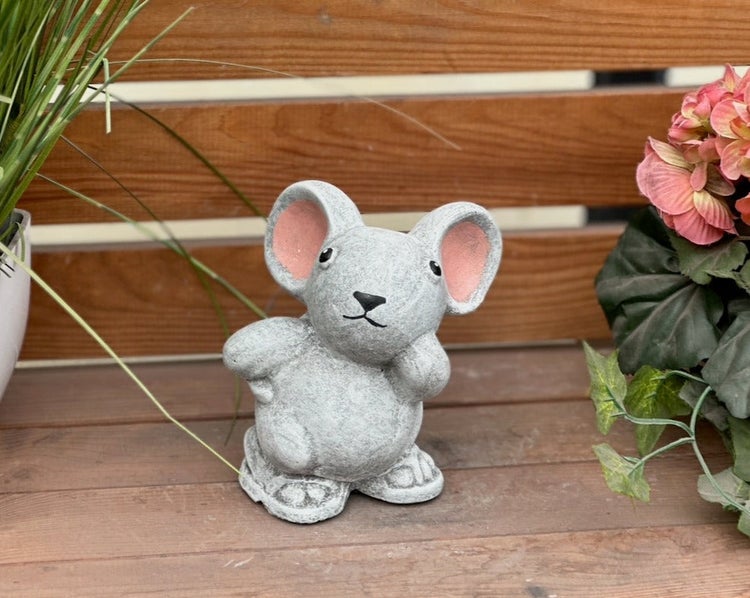 Dekorative Gartenfigur in Form einer Maus aus Stein auf einer Holzterrasse.