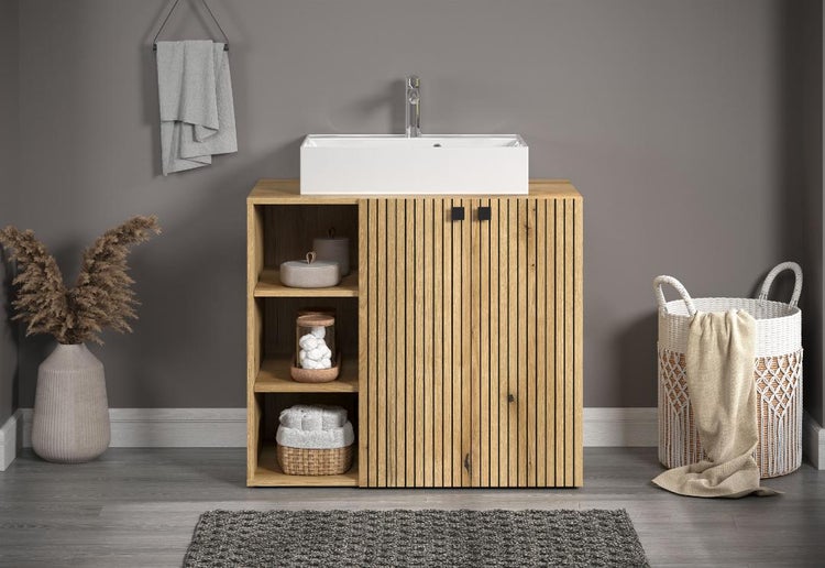 Badezimmer mit Waschtischunterschrank, Aufsatzwaschbecken, Handtuch und Dekoration