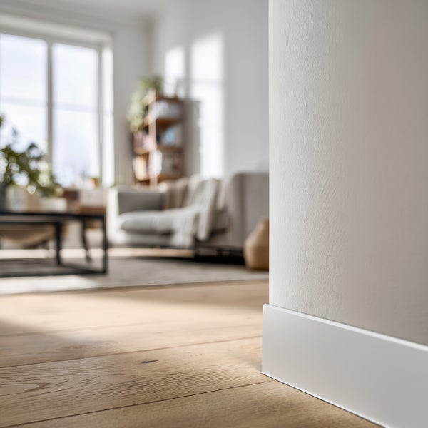 Heller Wohnraum mit Holzfußboden und weißen Fußleisten