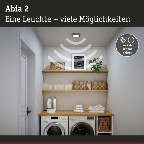 Hände montieren eine runde LED Einbauleuchte mit Bewegungssensor an einer Zimmerdecke.