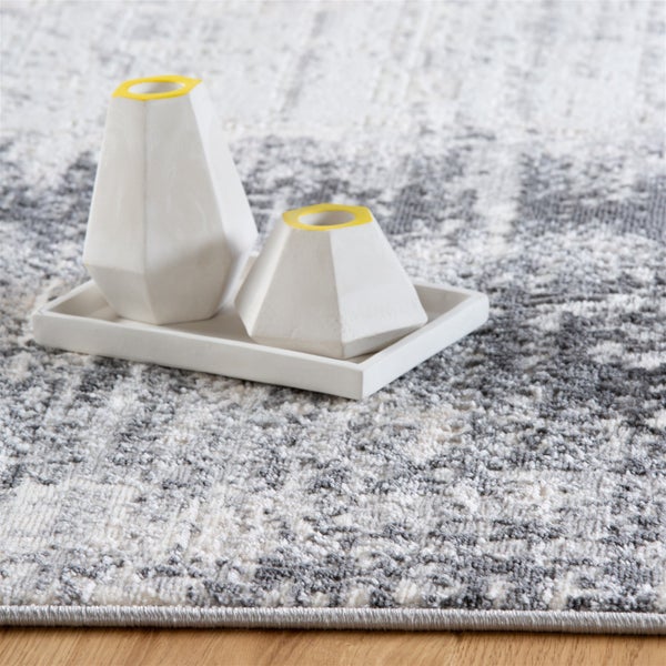 Teppich mit abstraktem grau-weißem Muster, Kurzflor, Nahaufnahme der Webstruktur mit Dekorationsvasen auf einem Tablett.