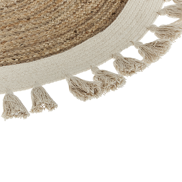 Detailansicht eines runden Teppichs aus Jute und Baumwolle mit geflochtener Struktur und dekorativen Quasten am Rand.