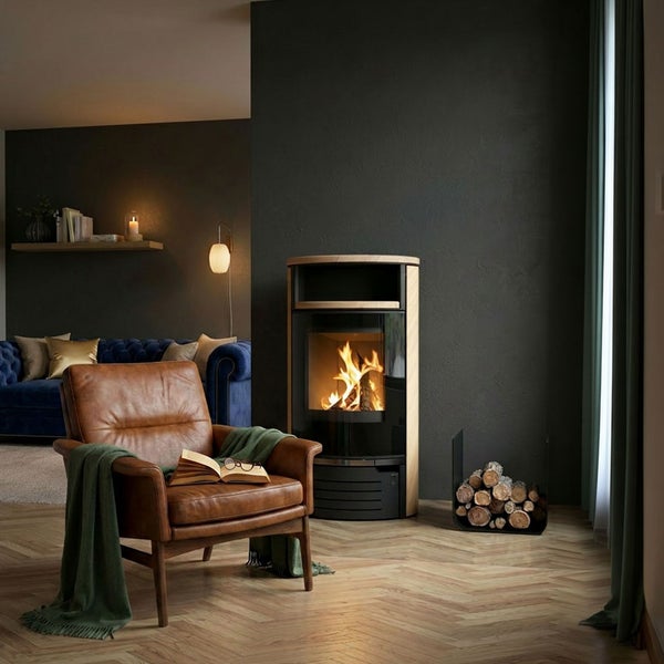 Moderner Kaminofen in einem gemütlichen Wohnzimmer mit Ledersessel und Holzstapel.