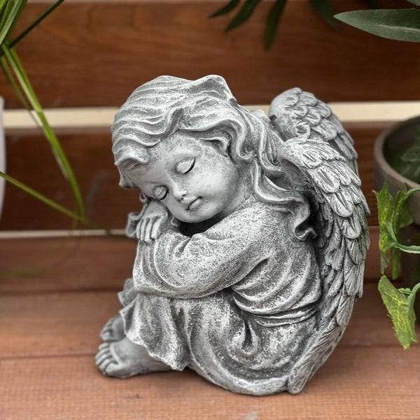 Steinfigur schlafender Engel als Gartenfigur aus wetterfestem Material zur Dekoration.
