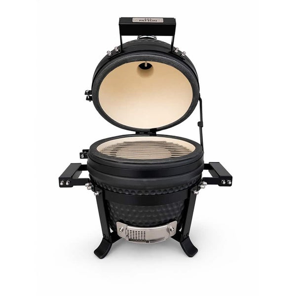 Patton Kamado Grill aus Keramik in Schwarz mit geöffnetem Deckel, Grillrost und seitlichen Griffen.