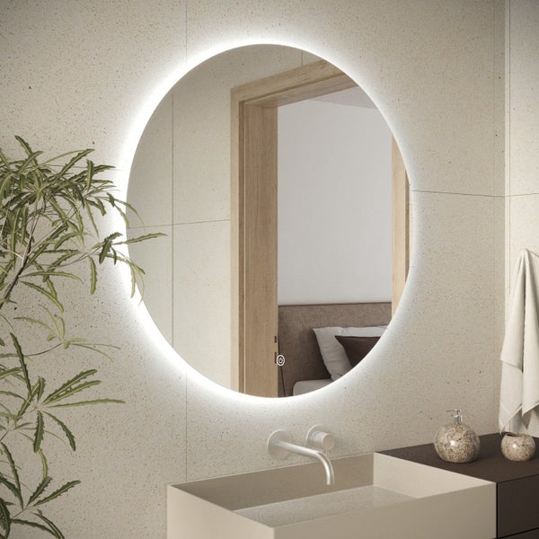 Runder LED Badezimmerspiegel mit integrierter Touch Beleuchtung an einer Fliesenwand über einem Waschbecken.