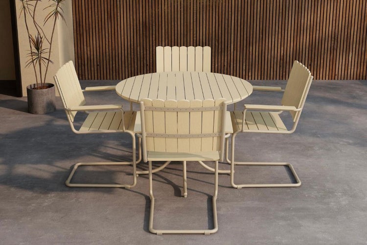 Modernes Gartenmöbel-Set mit einem runden Lattentisch und vier Freischwinger-Stühlen auf einer hellen Terrasse mit einer Holzlattenwand.