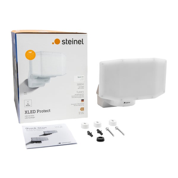 Steinel XLED Protect LED-Strahler in Weiß mit Originalverpackung, Bedienungsanleitung und Montagematerial wie Schrauben und Dübel.