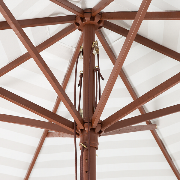 Innenansicht der Holzkonstruktion eines Sonnenschirms mit Seilzug und gestreifter Bespannung.