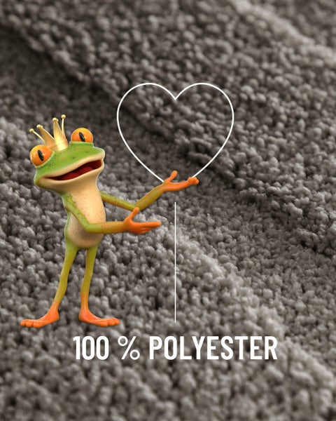 Nahaufnahme eines Teppichs mit Struktur, einer Froschfigur mit Krone und dem Schriftzug 100 Prozent Polyester.