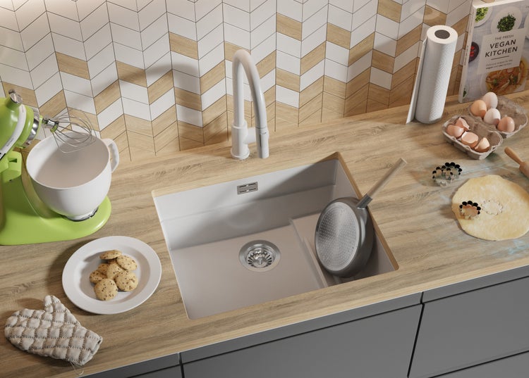 Küchenszene mit Spüle, Armatur, Arbeitsplatte und verschiedenen Küchenutensilien