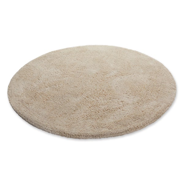 Nahaufnahme eines beigen Hochflor-Teppichs.