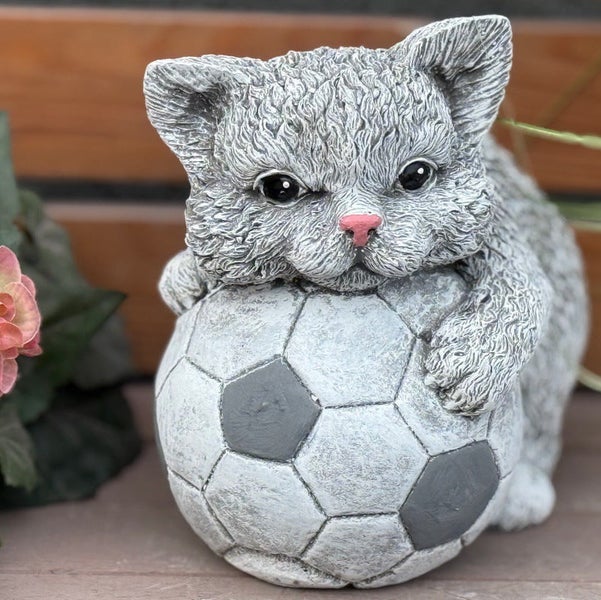 Dekorative Gartenfigur in Form eines Kätzchens, das mit einem Fußball spielt, aus witterungsbeständigem Material.