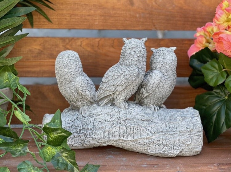 Drei Eulen als Gartenfigur aus Steinguss auf einem Baumstamm sitzend zur Dekoration im Außenbereich.
