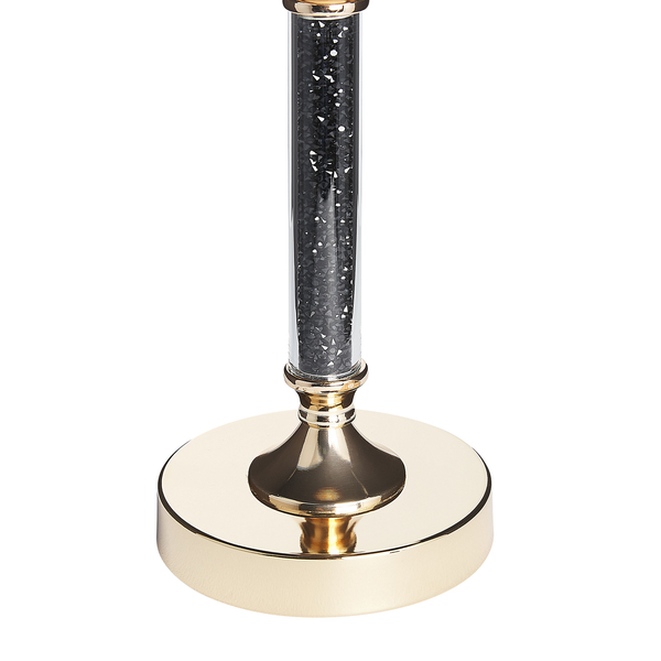 Dekorative Tischleuchte mit transparentem Schaft gefüllt mit Dekosteinen auf einem goldenen Sockel