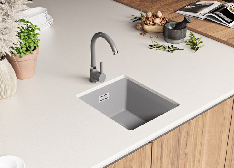 Küchenspüle und Wasserhahn auf einer Küchentheke mit Dekorationsgegenständen.