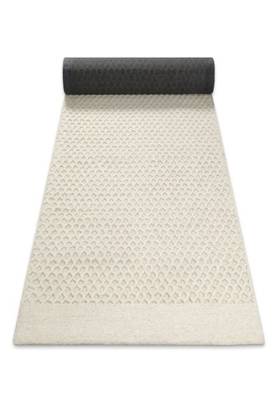 Beige Teppich-Läufer mit Rautenmuster und strukturierter Oberfläche, am oberen Ende leicht eingerollt.