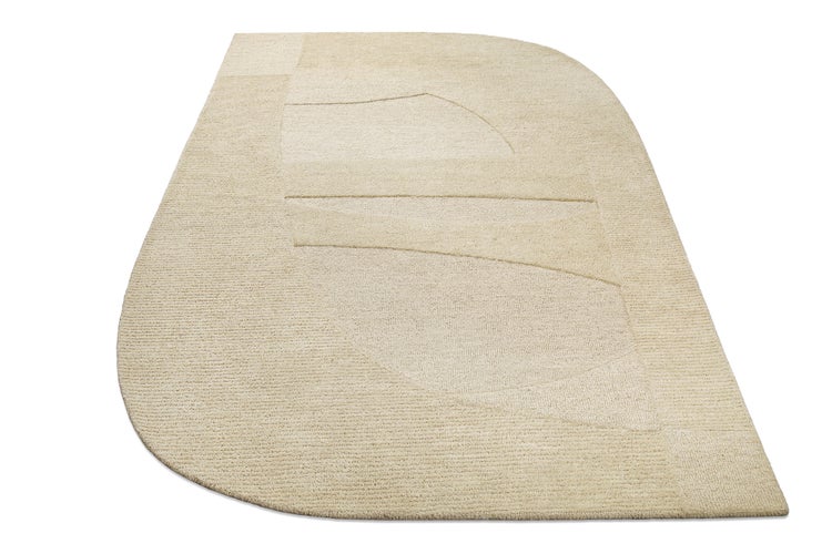 Beiger, unregelmäßig geformter Teppich mit geometrischem Reliefmuster und Kurzflor.