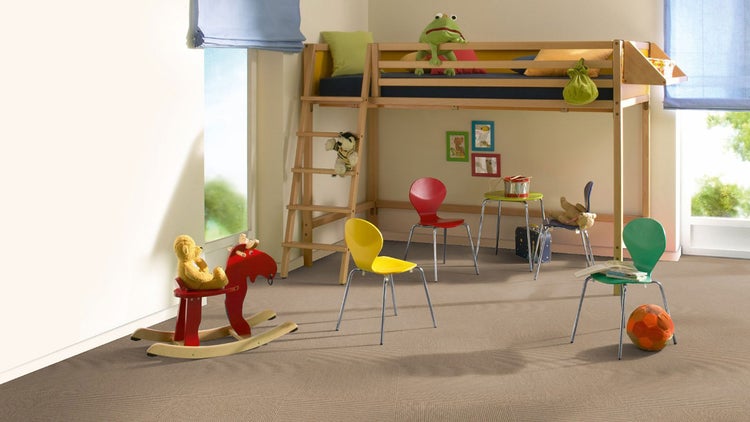 Helles Kinderzimmer mit hellbraunem, strukturiertem Teppichboden, Holz-Hochbett, bunten Stühlen und einem roten Schaukelpferd.