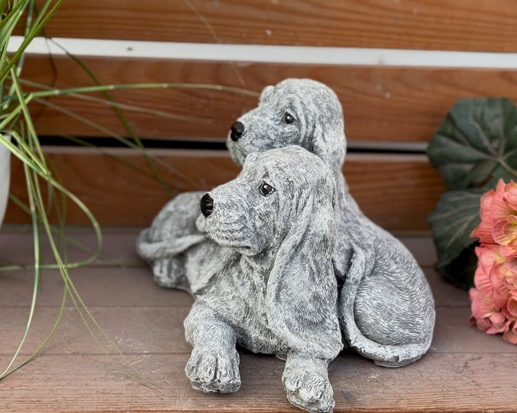Gartenfigur zwei liegende Hunde aus wetterfestem Steinguss.
