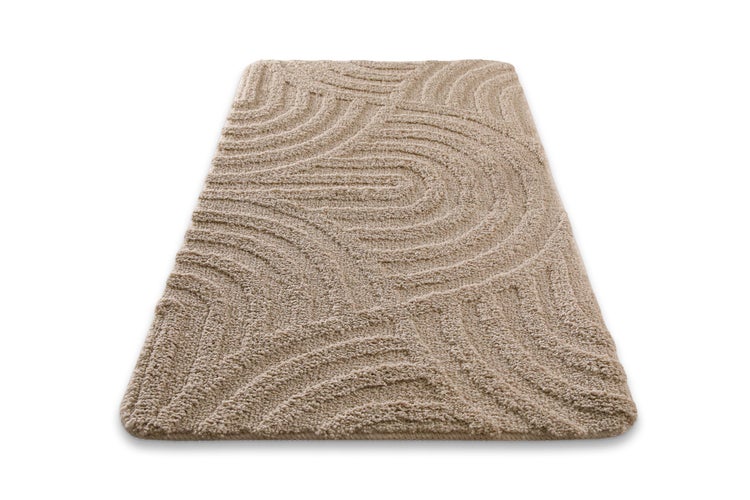 Beiger, rechteckiger Badteppich mit strukturiertem Wellenmuster und weichem Hochflor.