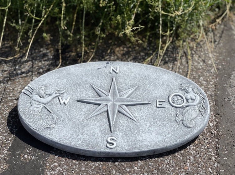 Ovale Trittplatte aus Steinguss mit Kompassrose sowie Meerjungfrau und Wassermann als Dekoration für den Garten