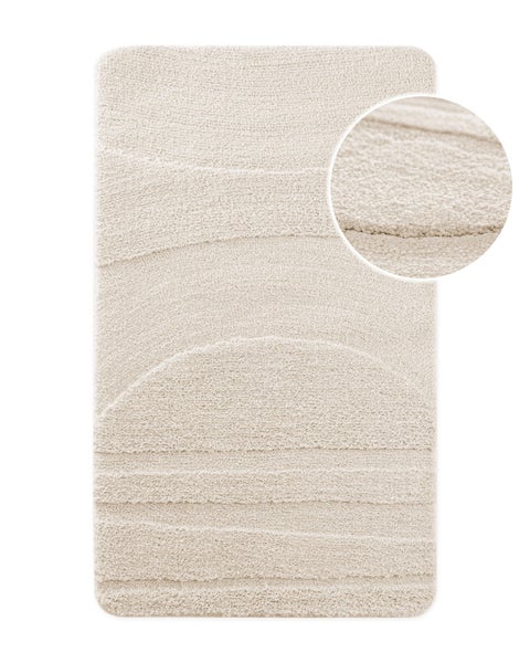 Beige Badematte mit Reliefstruktur in Wellenoptik und Detailansicht der weichen Oberfläche.