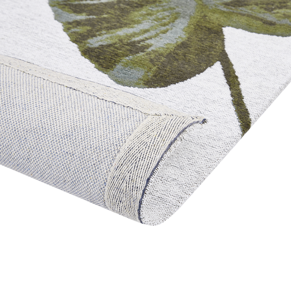 Detailansicht eines Teppichs mit Pflanzenmuster, der die Rückseite und die Webstruktur zeigt.