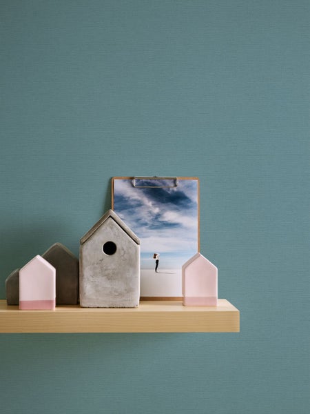 Szene mit Badaccessoires auf einem Holztisch vor einer einfarbigen Wand