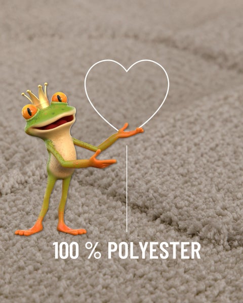 Ein grüner Frosch mit Krone auf einem Teppichboden mit einem Herzsymbol und dem Text 100 Prozent Polyester.