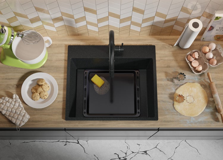 Küchenspüle mit Armatur, Backblech, Spülschwamm und Backutensilien auf einer Küchentheke