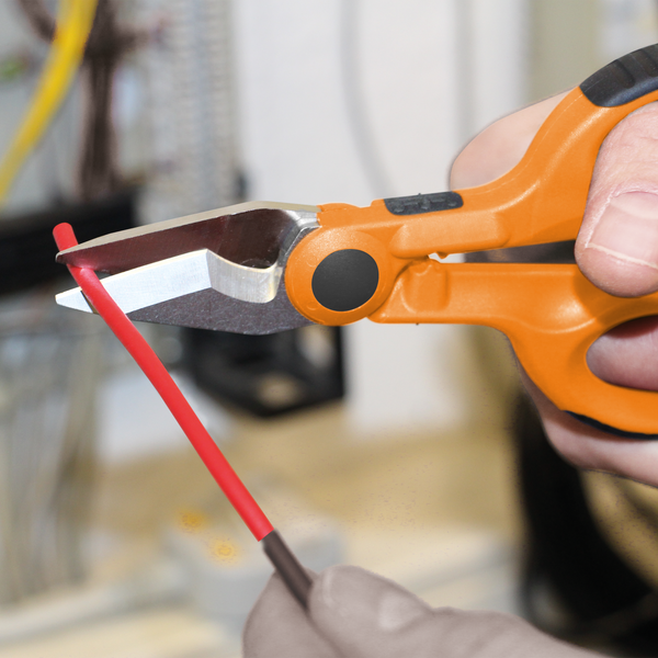 Eine Hand schneidet mit einem Seitenschneider ein Kabel durch.