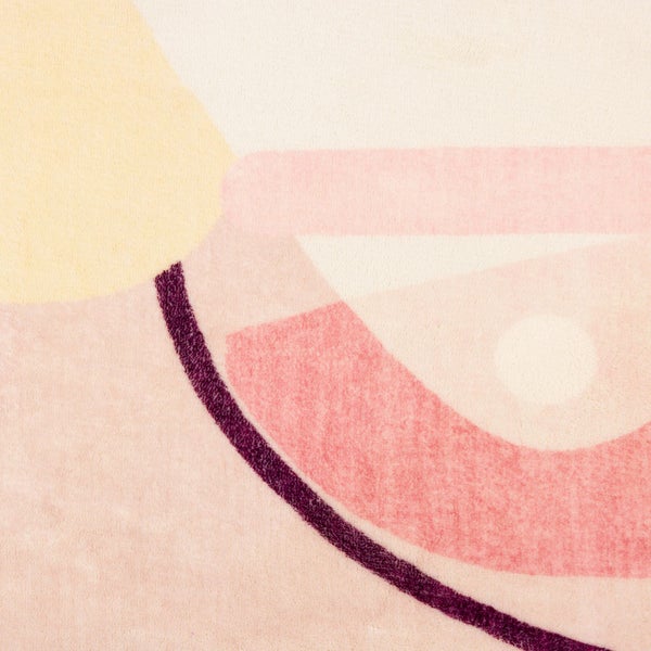 Detailansicht eines Teppichs mit abstraktem geometrischem Muster in Pastellfarben und weichem Flor.