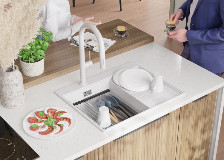 Küchenszene mit Spüle, Armatur, Geschirr und Speisen auf einer Küchentheke.