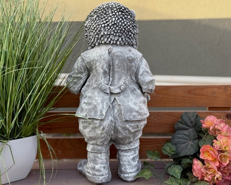 Gartenfigur Igel aus Steinguss in Steinoptik, Rückansicht mit detailreicher Jacke und Stacheln, stehend auf einer Holzbank.