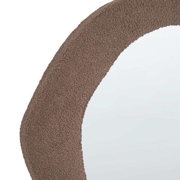 Detailansicht eines runden Spiegels mit einem texturierten Rahmen.