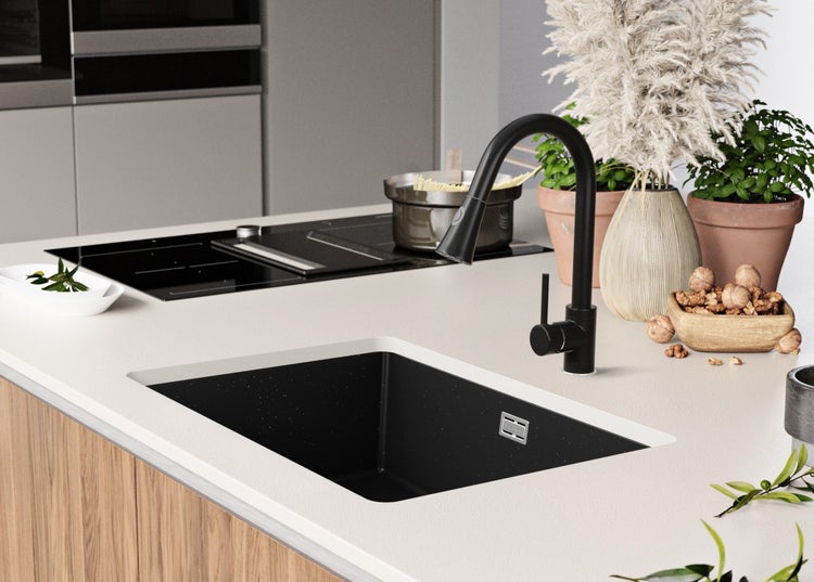 Küchenspüle mit Armatur und dekorativen Elementen auf einer hellen Arbeitsplatte