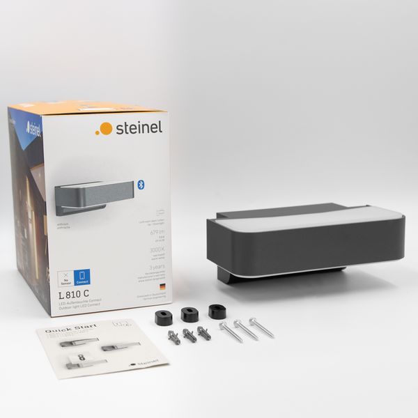 Steinel LED Außenleuchte L 810 C mit Verpackung, Montageanleitung und Befestigungsmaterial zur Wandmontage.