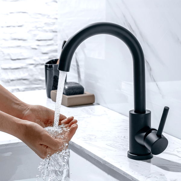 Moderne schwarze Waschtischarmatur mit Einhebelmischer an einem Waschbecken mit Händen unter fließendem Wasser.