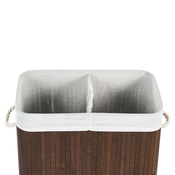 Wäschekorb aus Bambus mit Stoffeinsatz und Seilgriffen in einem hellen Badezimmer neben einer Badewanne.