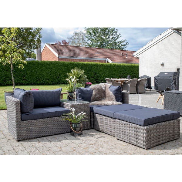 Gartenlounge-Set mit Rattan-Optik und Polsterkissen auf einer Terrasse