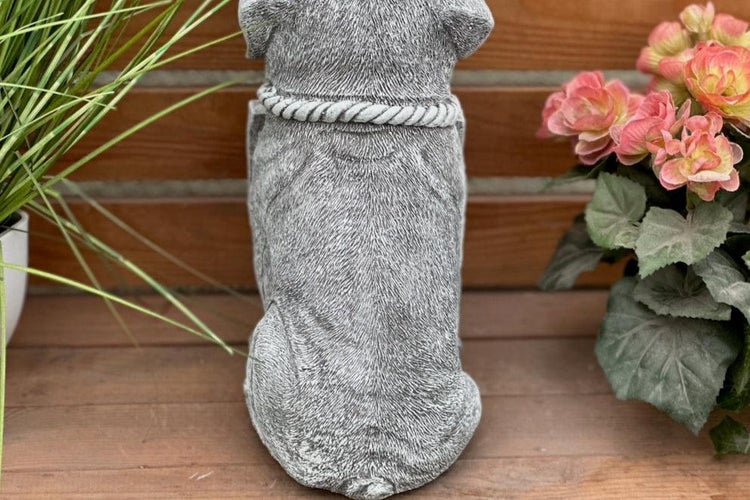Gartendekoration Hundefigur aus Steinguss in der Rückansicht, sitzender Hund mit strukturiertem Fell und Halsband auf Holzuntergrund.