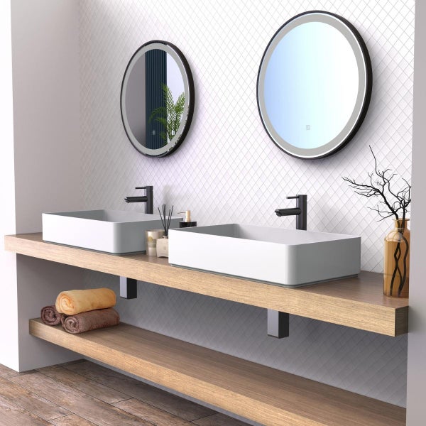 Modernes Badezimmer mit zwei Aufsatzwaschbecken auf einer Waschtischplatte aus Holz, ergänzt durch zwei runde LED Spiegel und dunkle Armaturen.