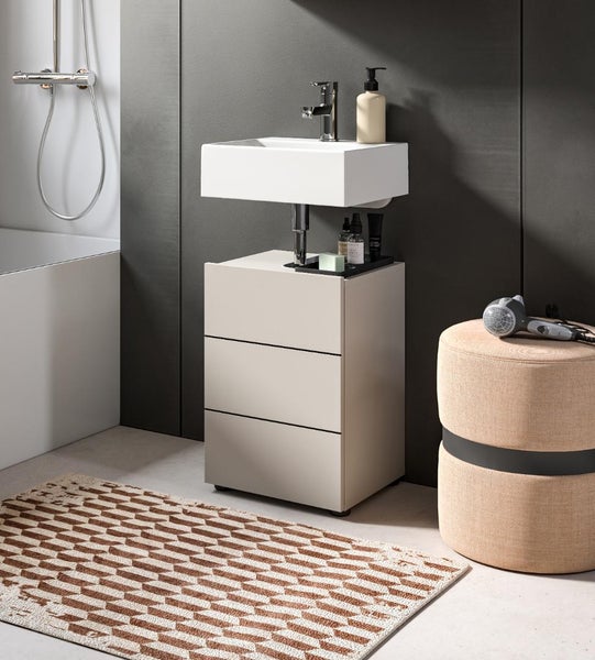 Badezimmer mit Waschbecken, Unterschrank mit drei Schubladen und Teppich