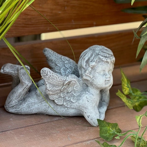 Dekorative Gartenfigur in Form eines liegenden Engels aus Stein für den Außenbereich.