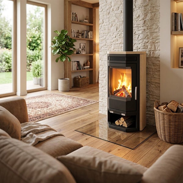 Moderner Kaminofen mit Sichtfenster und brennendem Feuer in einem hellen, gemütlichen Wohnzimmer mit Natursteinwand und Holzboden.