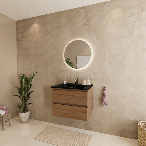 Modernes Badezimmer mit holzfarbenem Hängeschrank, schwarzem Waschtisch und einem runden LED Spiegel vor einer strukturierten beigefarbenen Wand.