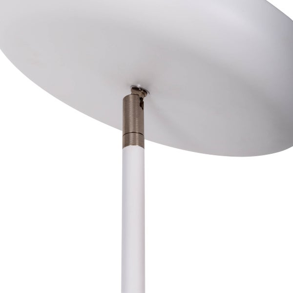 Szene mit beiger Couch, Decke, Stehlampe und Beistelltisch in einem Wohnzimmer.