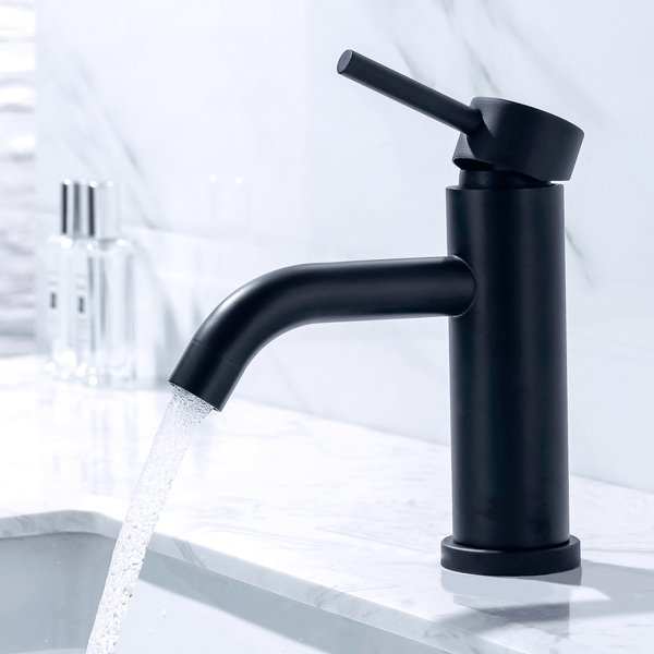 Moderne schwarze Einhebel Waschtischarmatur mit fließendem Wasser auf einem Marmorwaschbecken.