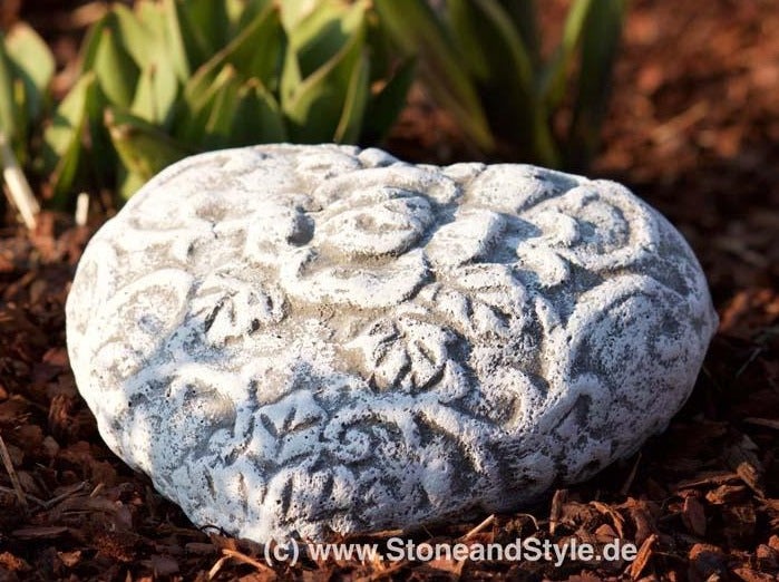 Steinornament in Herzform mit floralem Relief für den Garten